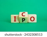 Small photo of ICO and IPO symbol. Wooden cubes with words ICO - initial coin offering and IPO - initial public offering. Beautiful green background. Business concept. Copy space