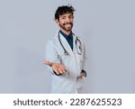 Small photo of Smiling doctor extending hand in welcome. Young doctor extending hand to camera, Smiling doctor extending hand isolated