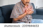 Small photo of Asian elder man suffering from central chest pain. Chest pain can be caused by heart attack, myocardial infarct or ischemia, myocarditis, pneumonia, oesophagitis, stress, anxiety, etc,.