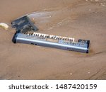 Small photo of New York, USA. Abandoned pianola or brought from the waters of the Hudson river on a beach of the Dumbo district. Environmental pollution. Act of vandalism. Lack of respect for the environment