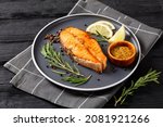 baked salmon steak with wholegrain mustard, lemon, rosemary on a plate, horizontal view from above