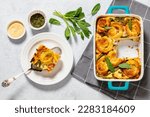 Small photo of asparagus ham strata topped with sponge cake circles in baking dish on concrete table with ingredients horizontal view from above, flat lay