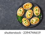 Small photo of Karelian pasties, karelian pies, pirogs, karjalanpiirakka, classic Finnish pastries of thin rye crust with rice filling, topped with egg butter on plate, horizontal view, flat lay, copy space