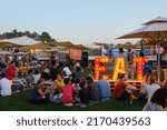 Small photo of Dubai, UAE - March 26, 2016: groups of people gathered for the Food Truck Jam, an outdoor event with food trucks and live music at the Emirates Golf Club.