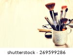 Various makeup brushes on light background with copyspace