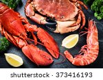Fine selection of crustacean for dinner. Lobster, crab and jumbo shrimp on dark background 