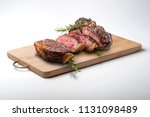 Fiorentina T-bone steak cut on rectangular wooden chopping board isolated on white background
