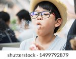 Small photo of Asian boy eating smoking canny happily - people and snack happy time concept