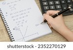 Small photo of Mathematical equation and graphs in a notebook, doing homework