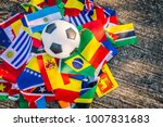 Above view of leather soccer ball on the ground with international team flags of the participating country in the championship tournament.Football equipment to play competitive game.World cup,Top-down