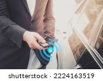The businessman opening his luxurious car door with a modern remote control key. The young man executive is locking the automobile with the security system. Keyless in male hand with copy space.