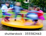Photo of children having fun at colorful carousel spinning round fast