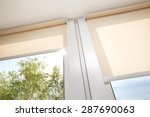 Window with sand coloured roll blinds