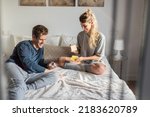 couple playing cards and having fun at home on bed
