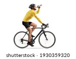 Profile shot of a male athlete riding a bike and drinking from a bottle isolated on white background