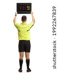 Small photo of Rear view of a football referee holding a substitute board isolated on white background