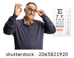 Mature man with an eye examination test holding his glasses and gesturing ok sign isolated on white background