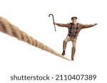 Small photo of Elderly man walking on a tightrope and holding a cane isolated on white background