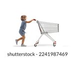 Full length profile shot of a little girl pushing a big empty shopping cart isolated on white background