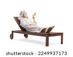 Woman in a bathrobe laying with a face mask and cucumbers on eyes and holding a glass of cocktail isolated on white background