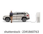 Small photo of Mature man with a SUV plugged into an electric vehicle charging station isolated on white background