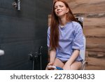 Small photo of Portrait of scared and desperate pregnant young woman checking positive result on pregnancy test sitting on toilet WC at home bathroom. Crying in unwanted pregnancy and unplanned motherhood