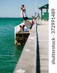 Small photo of MELBOURNE/AUSTRALIA - FEBRUARY 6: Youths jump off a jetty into the water, while others fish in Mordialloc, a coastal suburb of Melbourne, Australia in February.