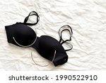 Black bra and stainless steel bra wire on fabric background. Photo can be used for Pros and Cons of Underwired Bras concept. Copy space is on the right side.