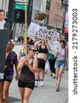 Small photo of Knoxville, TN, USA - June 26, 2022: Protestors march after Roe v Wade overturned. One protestor shares opinion of Supreme Court, another carries cutout of late Ruth Bader Ginsburg.