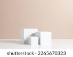 Small photo of White quadrate pastel background for product presentation with shadow on beige table background. Podium, stage pedestal platform for cosmetic product. Empty square podium. Mockup.