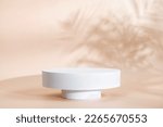 Small photo of Beige background for product presentation with shadow of tropical palm leaves and light. Podium, stage pedestal platform for cosmetic product. Empty round podium. Mockup.