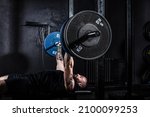 Strong sweaty muscular athlete fit active man doing hardcore bench press with heavy barbell weights in the gym. Active male bodybuilder workout and cross training concept. Real people exercise