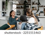Small photo of Two young women friends roommates business partners and owners of a small business are arguing at home due to the inappropriate spending of money and increased expenses on household bills.