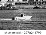 Small photo of Portsmouth Harbour, Hampshire, England. February 14th 2023. Black and white. A small boat, Old Buoys 2, a Quicksilver 640 vessel, passing Gunwharf Quays.