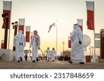 Small photo of Doha, Qatar - December 2, 2022: The Qatari men walking at the Al Darab Saai at Umm Salal Mohamad in Doha, Qatar. During celebrate Qatar national day.