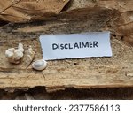 Small photo of Disclaimer writing on beach sand background.