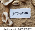 Small photo of Intonation writing on beach sand background.