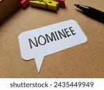 Small photo of Nominee writting on table background.