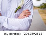 Groom in white shirt with calla lilie boutonniere, hand with golden wedding ring on finger, just married close up shot