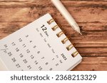 December 2023 - Closeup of a small desktop calendar with wooden table background, time and business concept