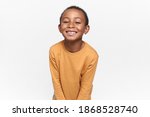 Small photo of Positive emotions, joy and happy childhood. Adorable black boy posing against blank white copy space studio wall background, looking at camera with broad cheerful smile, anticipating holidays