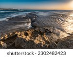 Small photo of Crevasse in rocky beach at golden hour Nacholim Israel