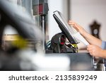 Small photo of Concept of small business or sevice, woman or saleswoman in apron at counter with a cashbox working at clothes shop, touchscreen POS, finance concept, business