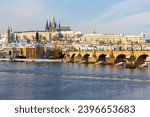Snowy Prague Lesser Town with Prague Castle and Charles Bridge above River Vltava in the sunny Day , Czech republic