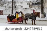 Small photo of Rossiya, Suzdal, 2017. Russian traditional sleigh pulled by a saddle horse. Entertainment for tourists in Russia. Snow-covered old town. An old Orthodox church. Russian troika