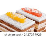 Small photo of two slices of multilayer cocoa sponge cake with coconut flakes