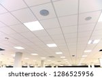 Modern design white office ceiling with white tiles and lighting