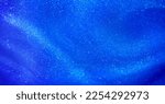 Small photo of Blue liquid background with small pearlescent luminous particles. Abstract textured Blue flowing waves background with shiny streaks. Magic blue waves with tints of silver dust particles.