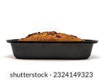 Freshly baked homemade chocolate banana bread in loaf pan. Isolated on white background with copy space. Side view.
