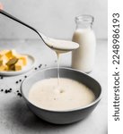 Small photo of Delicious bechamel sauce in a dish and served with a spoon. Bechamel sauce to accompany your meals. Bechamel sauce classic French gastronomy.